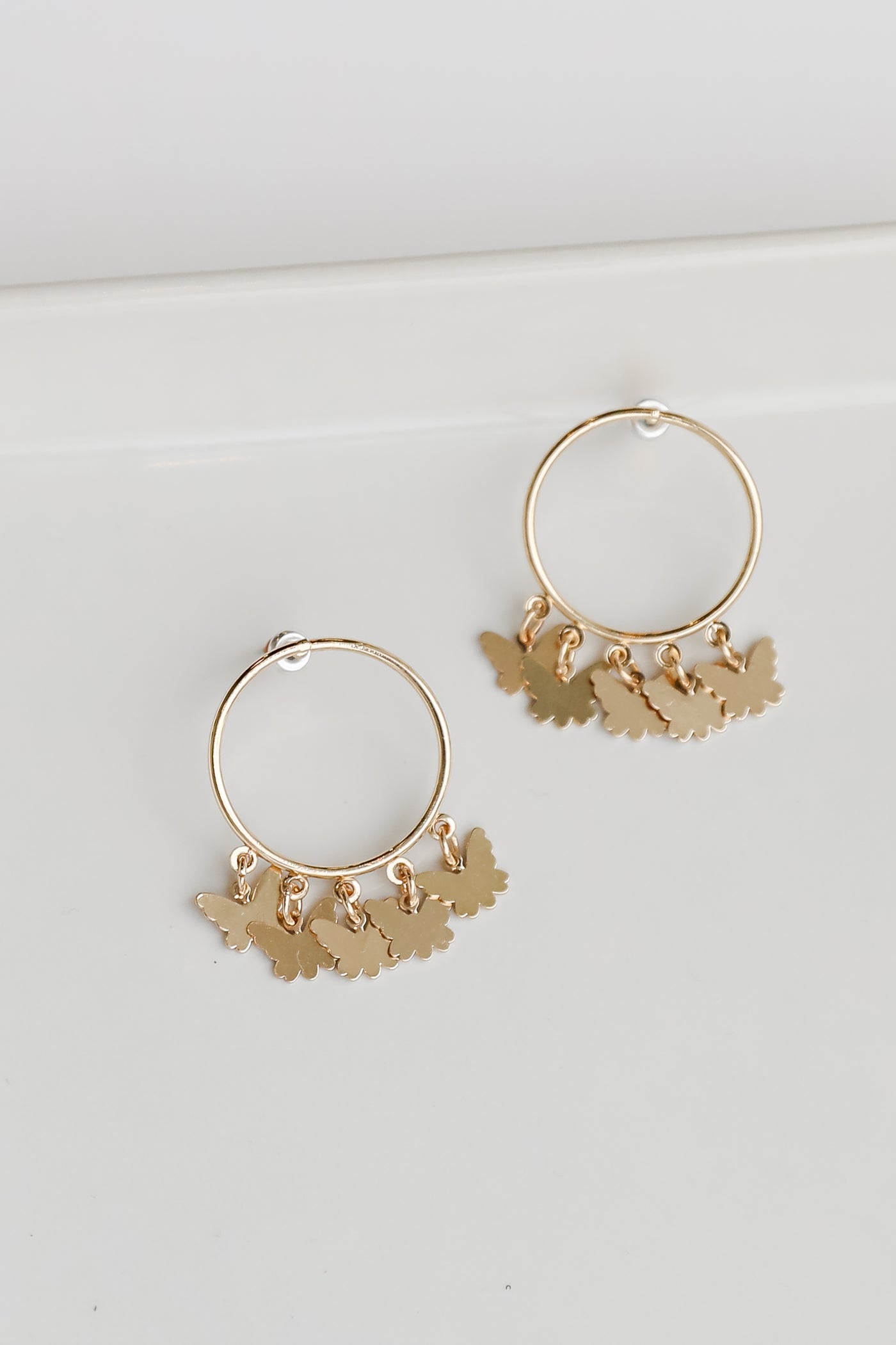 Gold Butterfly Charm Earrings flat lay
