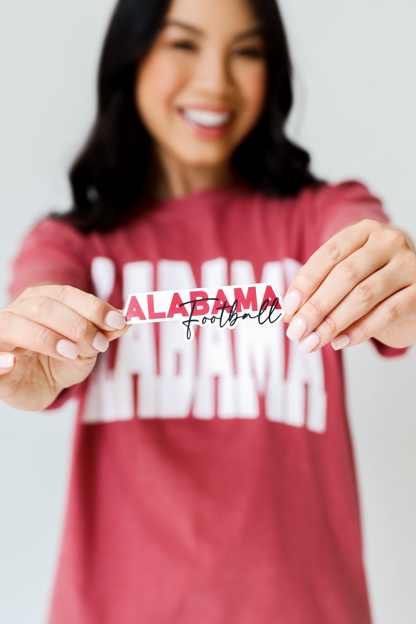 model holding the Alabama Football Sticker
