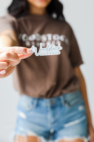 model holding the Woodstock Georgia Script Sticker