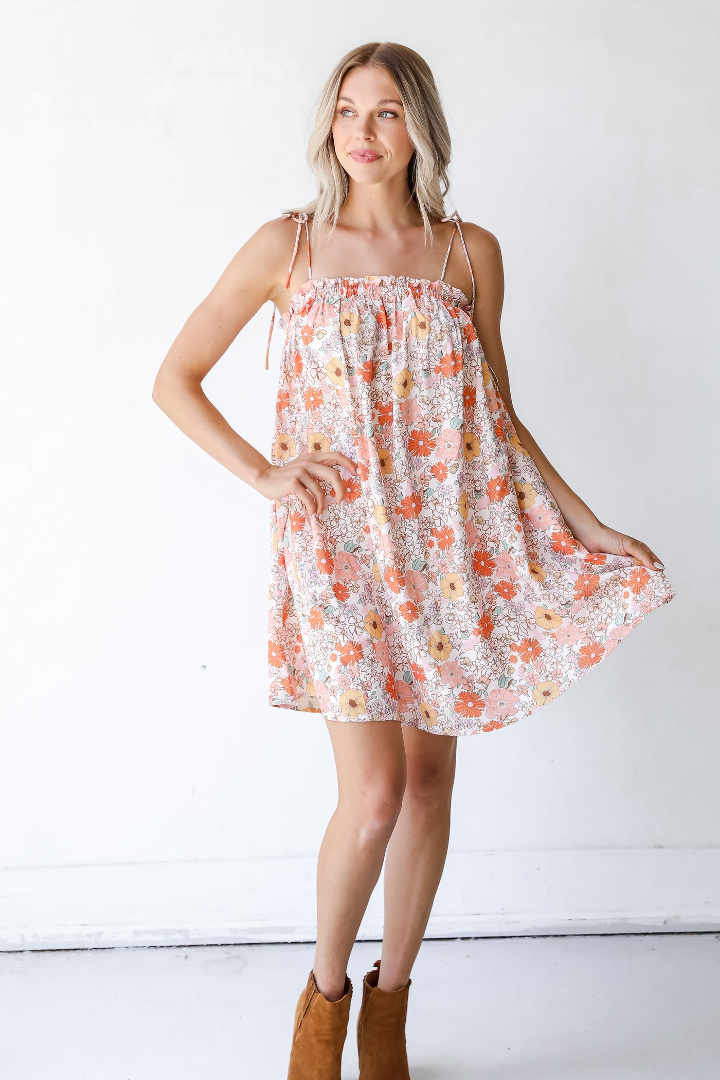 model wearing a Floral Mini Dress with tan booties