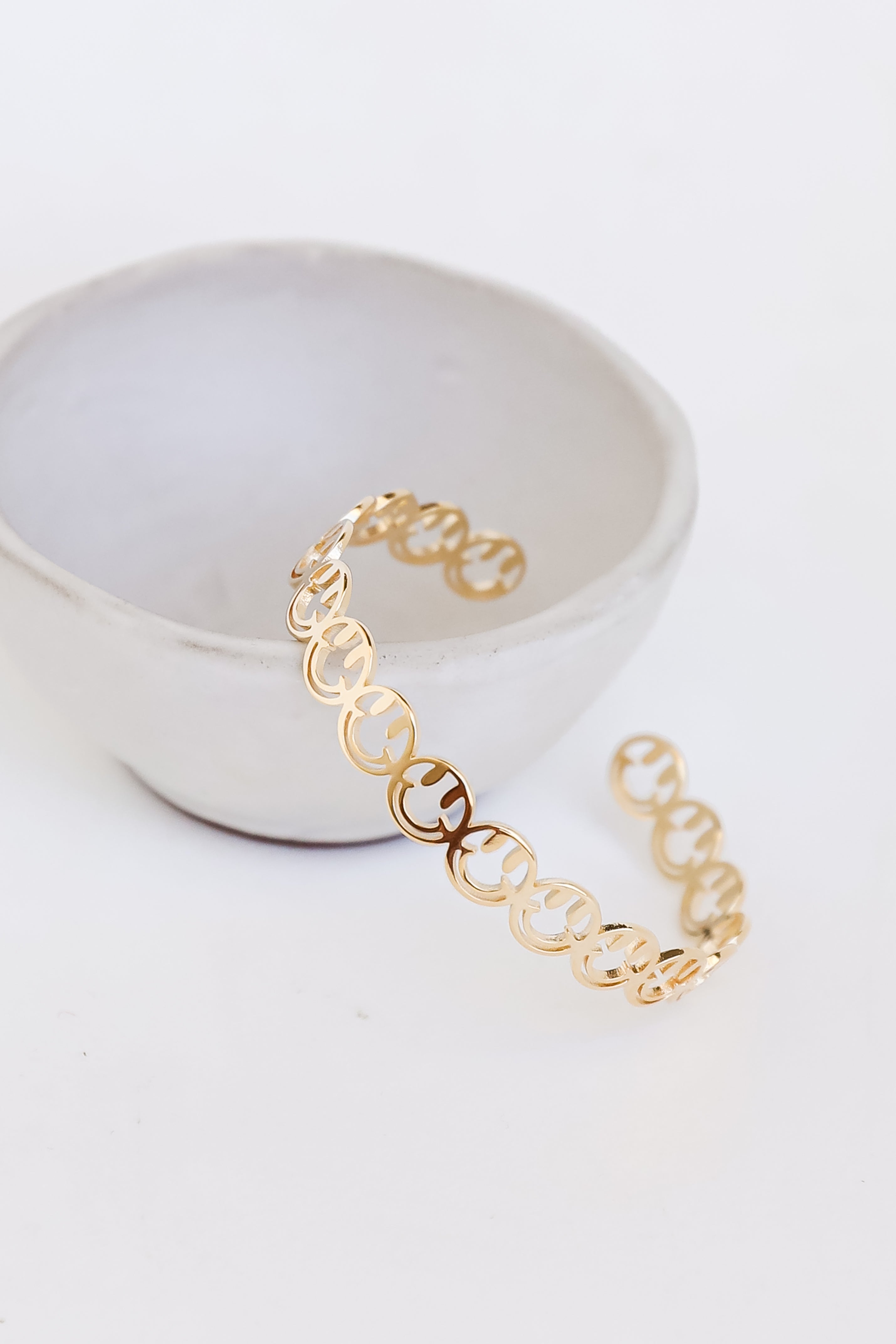 Gold Smiley Face Cuff Bracelet flat lay