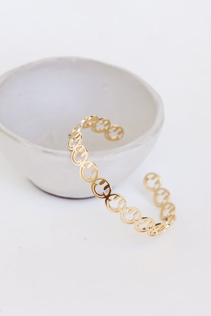 Gold Smiley Face Cuff Bracelet flat lay