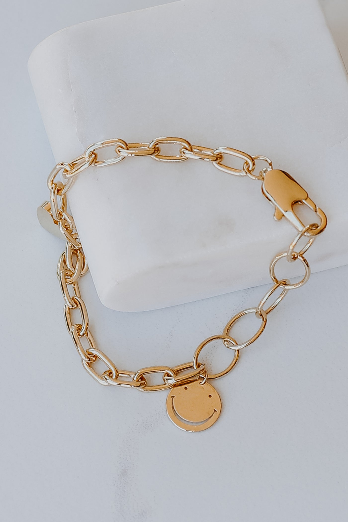 close up of a Gold Smiley Face + Heart Charm Bracelet