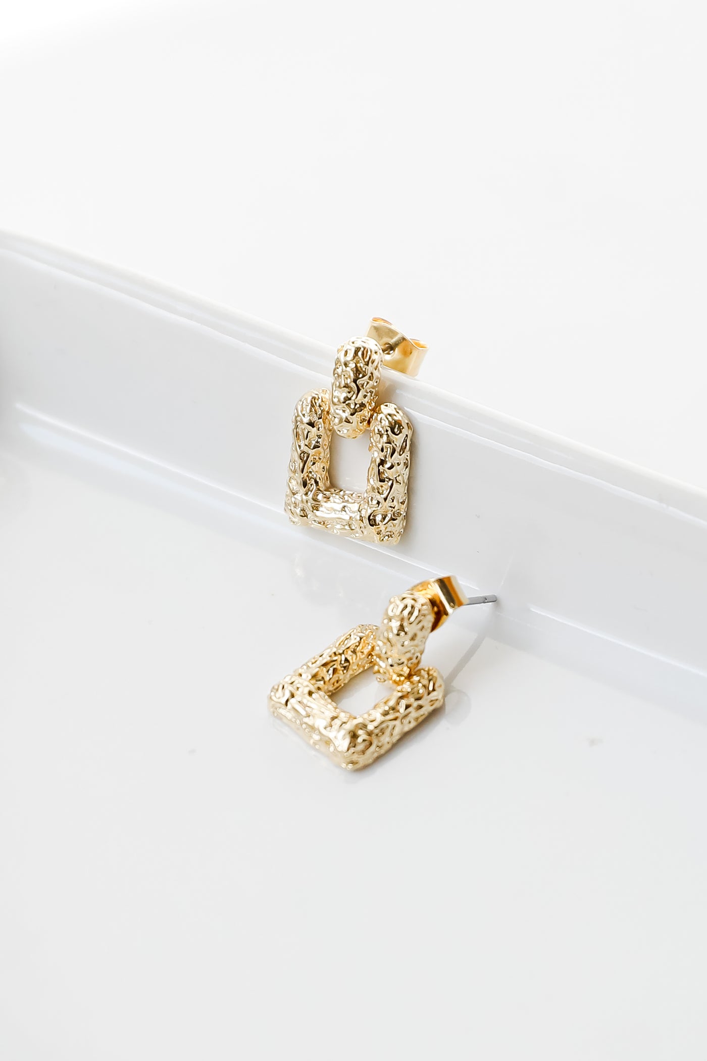 close up of gold statement earrings