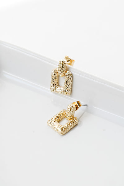 close up of gold statement earrings