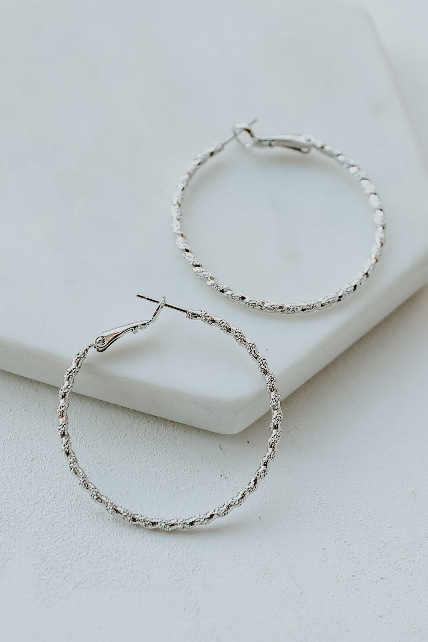 Textured Small Hoop Earrings flat lay in silver