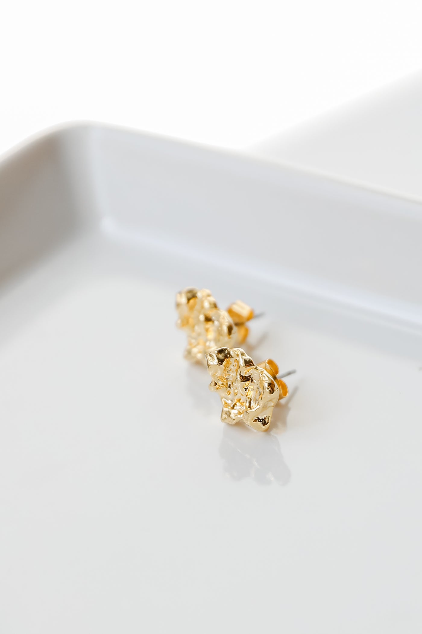 close up of gold hammered stud earrings