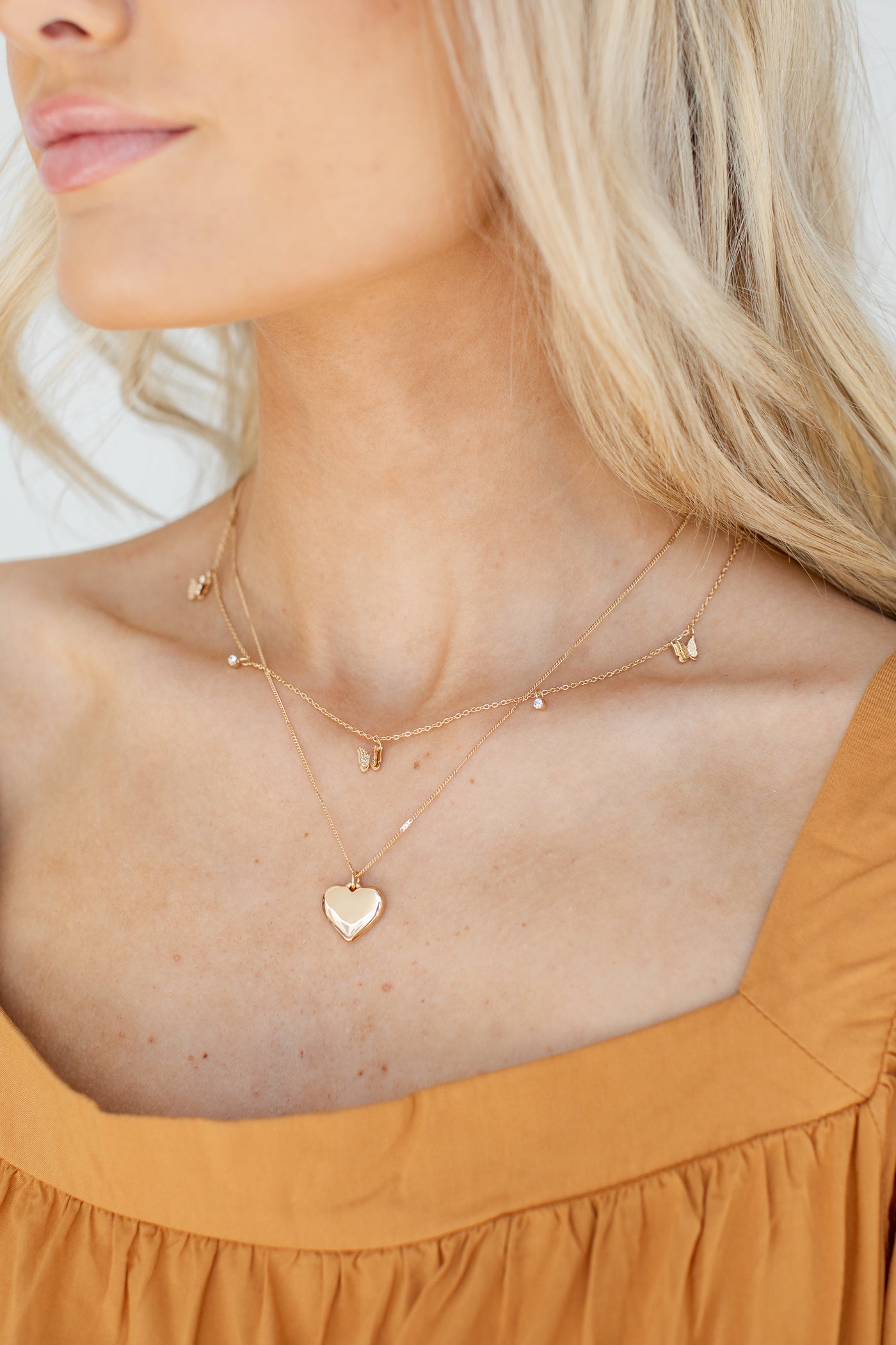 Gold Butterfly + Heart Layered Necklace on model