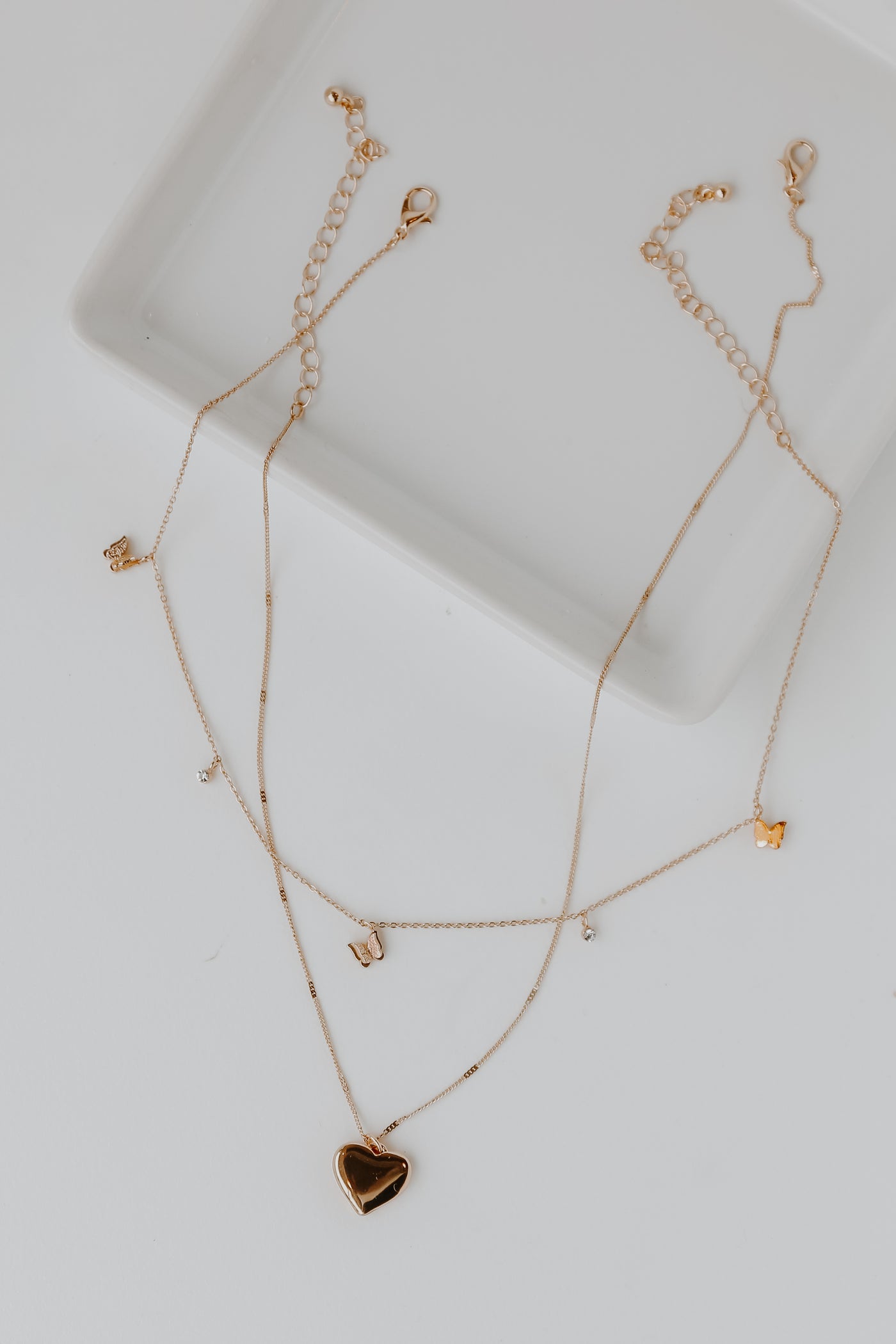 Gold Butterfly + Heart Layered Necklace flat lay