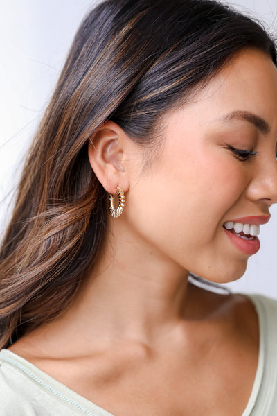 model wearing textured gold hoops