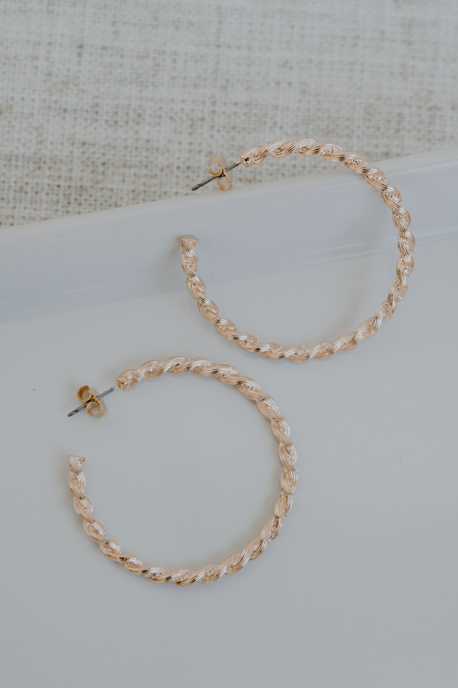 Gold Twisted Hoop Earrings flat lay
