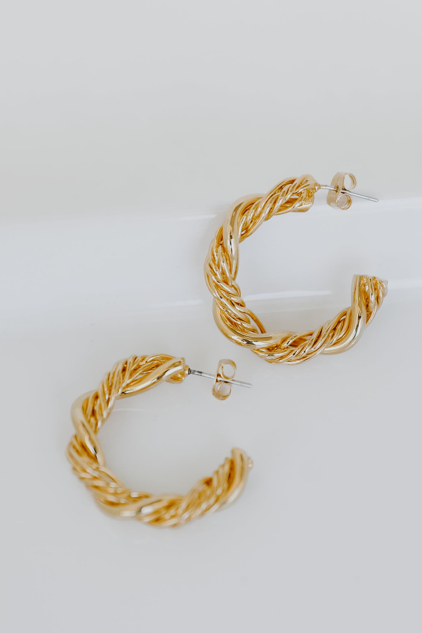 Gold Twisted Hoop Earrings flat lay