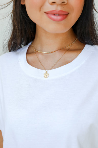 dainty gold necklace on model