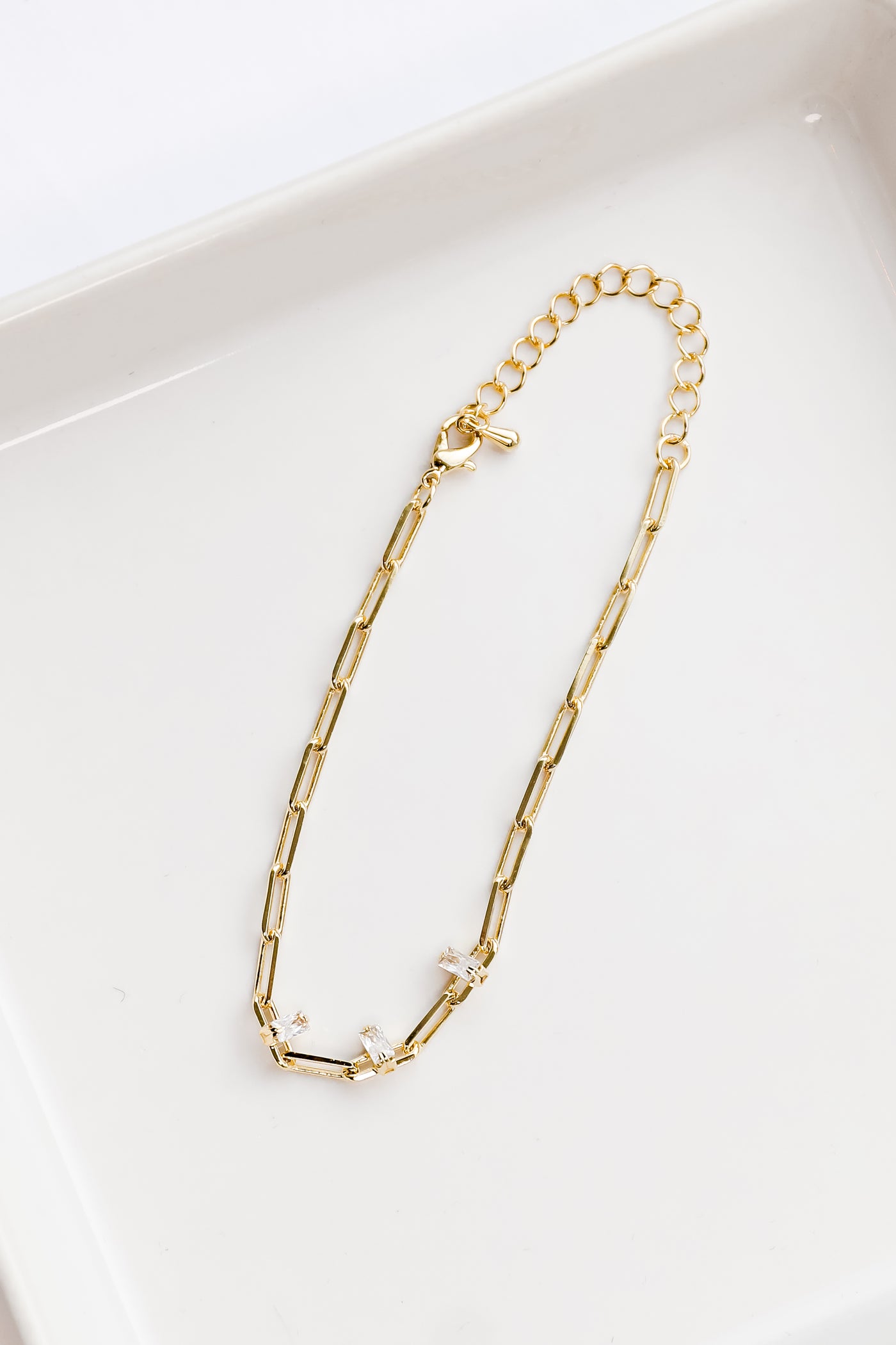 gold chain bracelet flat lay