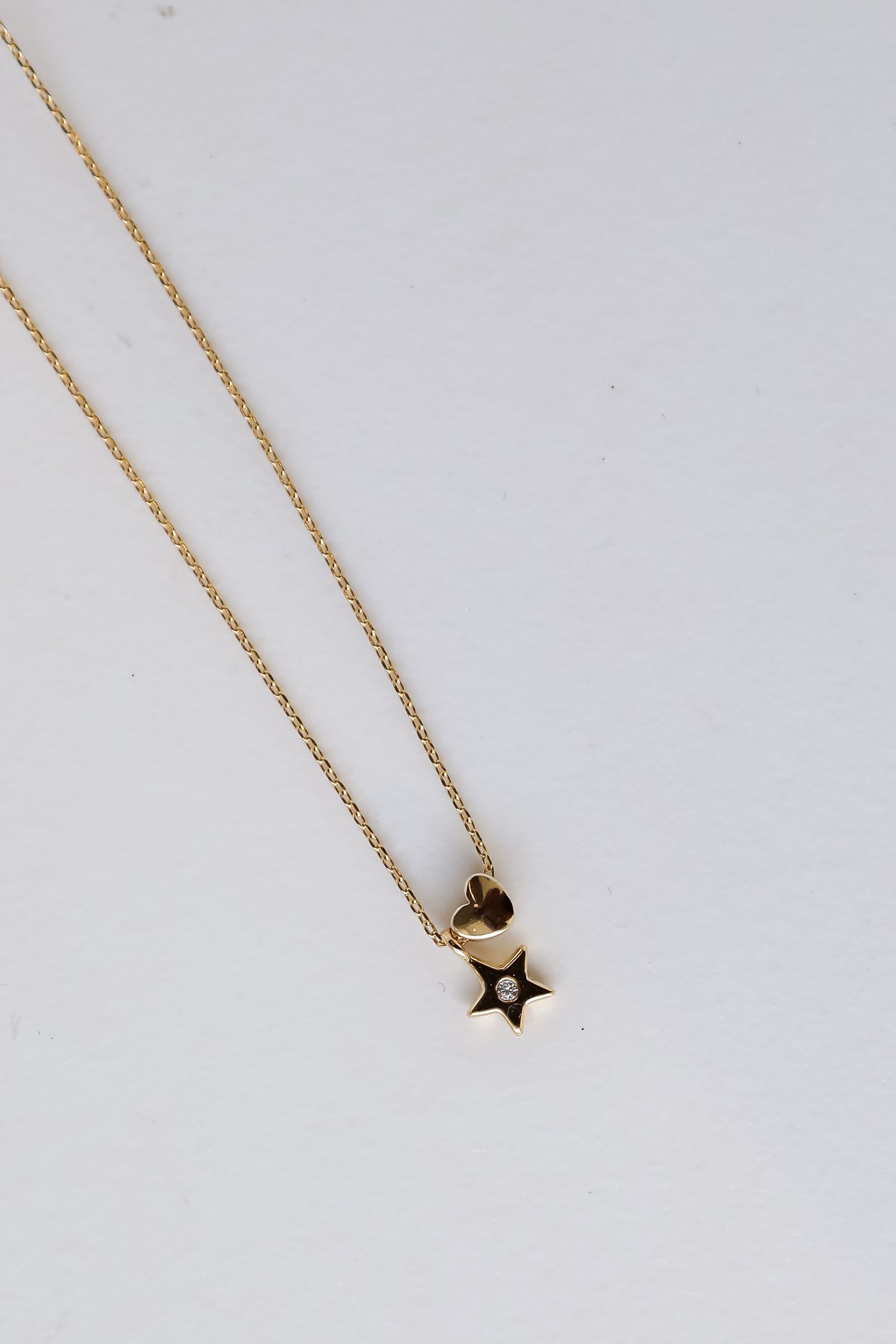 Gold Star + Heart Charm Necklace flat lay