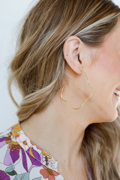 Gold Wavy Hoop Earrings on model