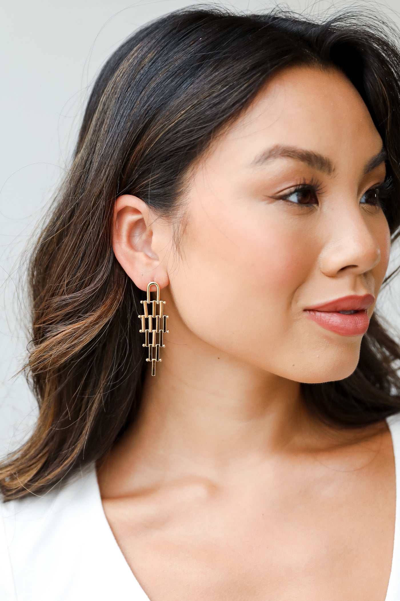 gold tiered earrings on model