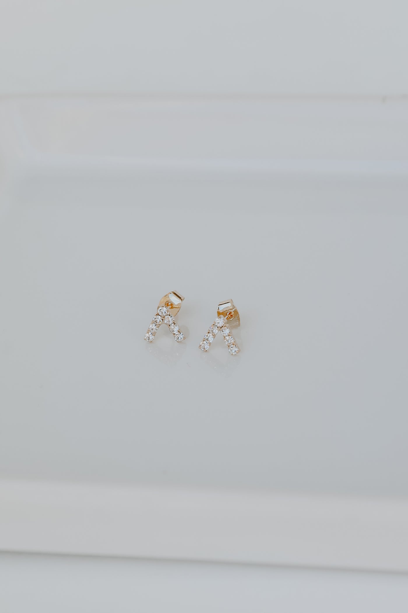 Gold Rhinestone V Stud Earrings flat lay