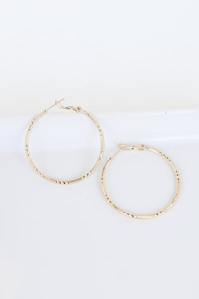 Gold Textured Medium Hoop Earrings flat lay