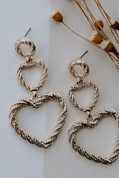 flat lay of gold heart earrings