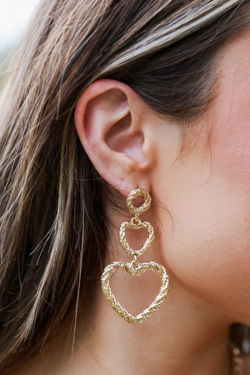 model wearing gold heart earrings