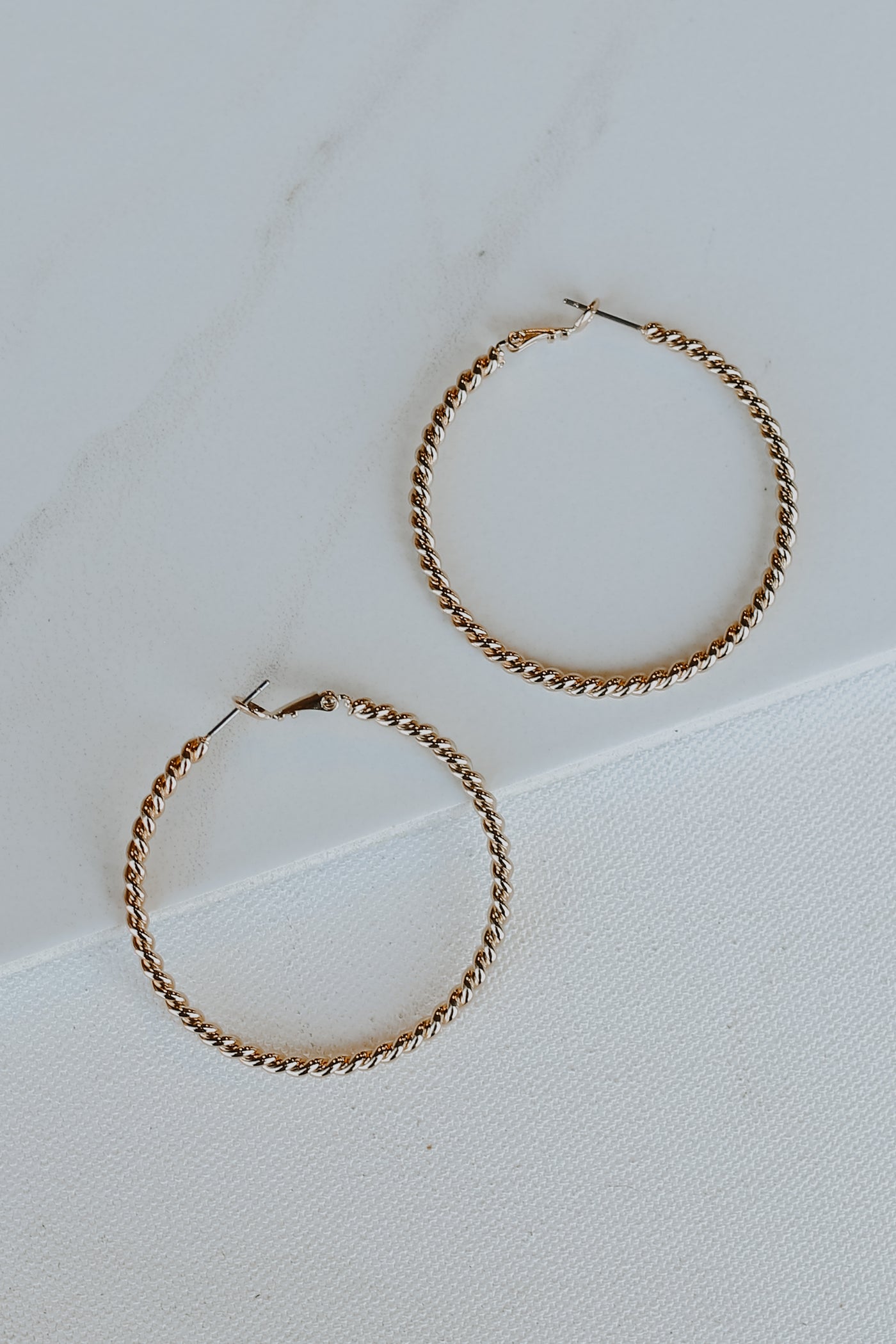 Gold Twisted Hoop Earrings flat lay