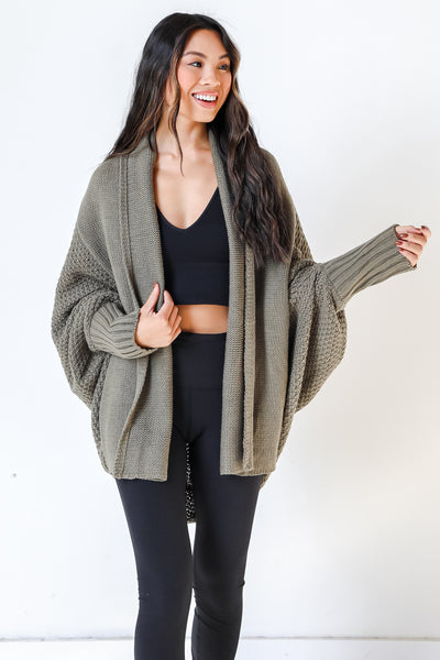 model wearing olive sweater cardigan with black top and leggings