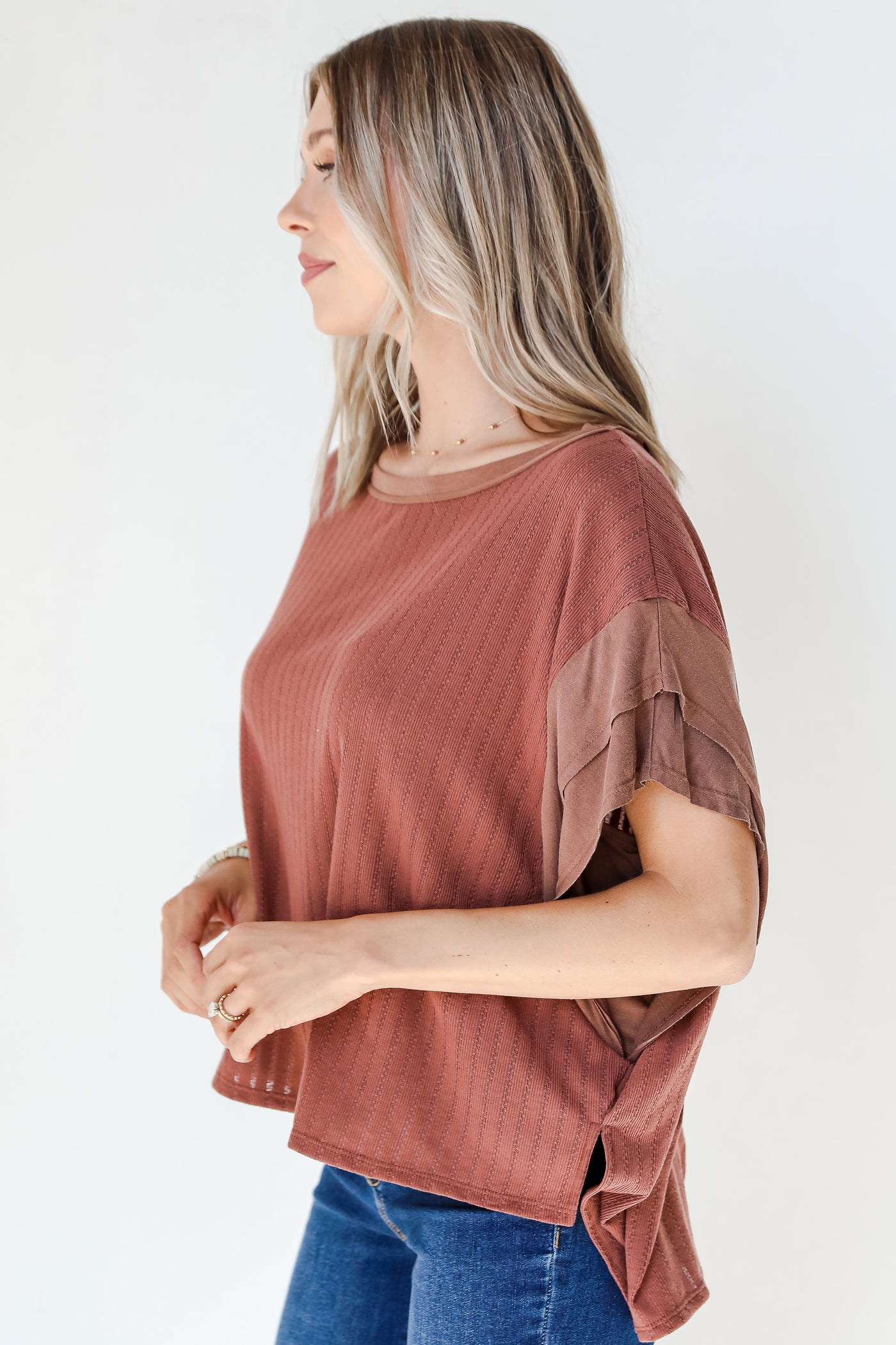 side view of a brown ruffle sleeve top