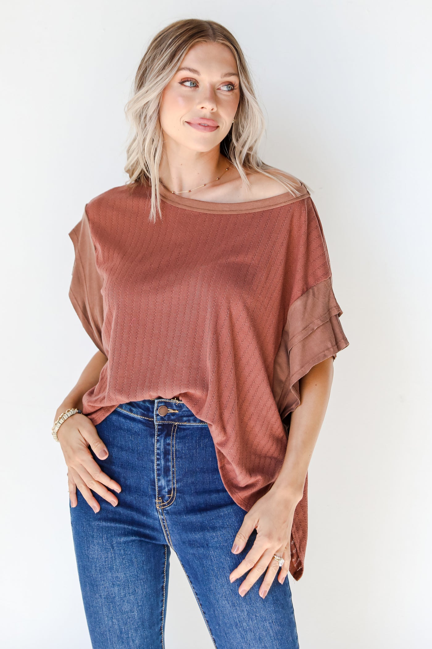 model wearing a brown knit top with dark wash jeans