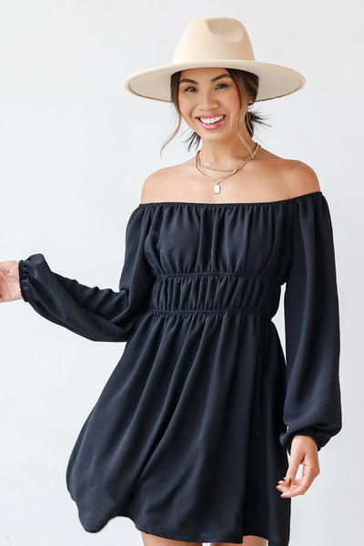 This cute dress is designed with a lightweight textured woven knit. It features an elastic off-the-shoulder neckline, long balloon sleeves with elastic cuffs, and elastic waistband, and a flowy fit that ends at a mini length.