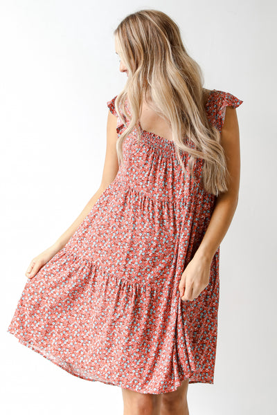 model wearing a rust floral dress