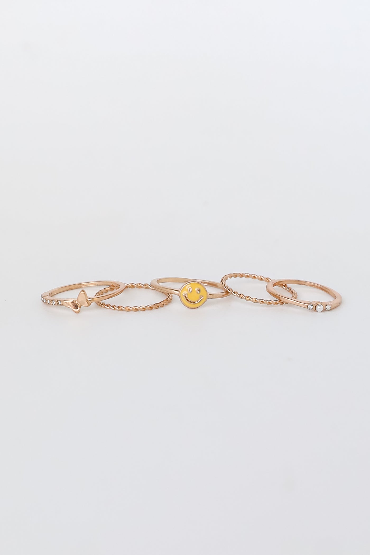 Gold Butterfly + Smiley Face Ring Set flat lay