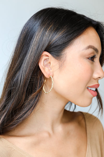 gold hoop earrings on model