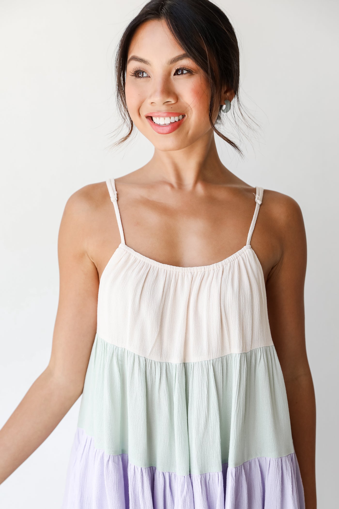 front view of a model wearing a color block tiered tank