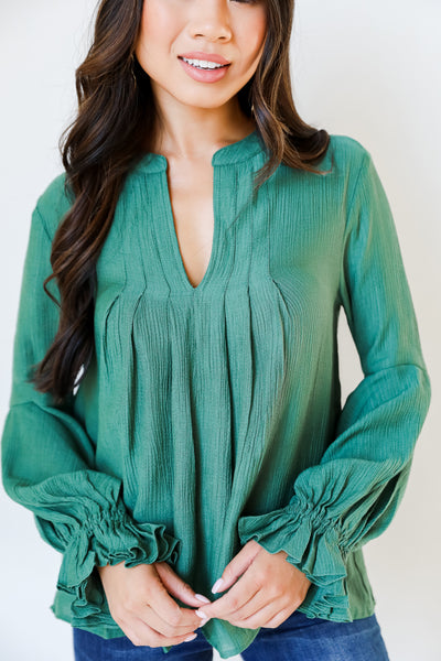 green flounce sleeve blouse on model