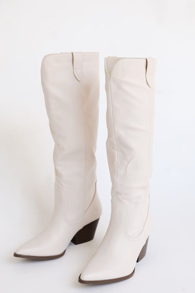 white tall boots flat lay