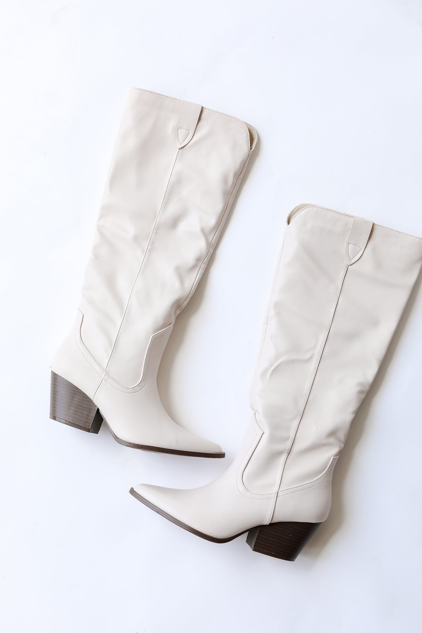 white tall boots flat lay